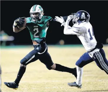  ?? [PHOTO BY SARAH PHIPPS, THE OKLAHOMAN] ?? McGuinness’s Dominic Richardson gets by Altus’ Noah Briones during Friday’s playoff game at Bishop McGuinness High School in Oklahoma City. Bishop McGuinness won, 38-14.