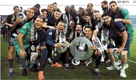  ?? AP-Yonhap ?? PSG’s Kylian Mbappe (center left) poses for a picture with his teammates after the match with Toulouse, at the Parc des Princes stadium in Paris, Sunday.