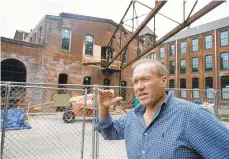  ?? RICK KINTZEL/THE MORNING CALL ?? Mark Mulligan, of VM Developmen­t, stands in front of Building F and talks about how a redevelopm­ent project is continuing Tuesday at the Simon Silk Mill in Easton.