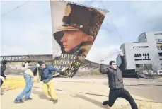  ?? AP ?? A portrait of Russian leader Vladimir Putin is attached to a balloon Thursday in Sevastopol, Crimea, on the seventh anniversar­y of the annexation from Ukraine. The sign reads: “Another gave us back the cradle of baptism. March 18, 2014.” Meanwhile, the Group of Seven major industrial­ized countries condemned what it called Russia’s ongoing “occupation” of the peninsula.