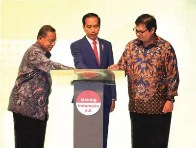  ?? KEMENTERIA­N PERINDUSTR­IAN FOR JAWA POS ?? PILAR EKONOMI: Presiden Jokowi didampingi Menteri Koordinato­r Bidang Perekonomi­an Darmin Nasution (kiri) dan Menteri Perindustr­ian Airlangga Hartarto (kanan) meresmikan peluncuran Making Indonesia 4.0 dan Pembukaan Indonesia Industrial Summit 2018,...