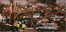  ?? Associated Press ?? In this May 22, 2011, file photo, emergency personnel walk through a severely damaged neighborho­od after a tornado hit Joplin, Mo.