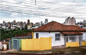  ?? Ricardo Chicarelli ?? Casas construída­s com peroba das matas nativas na vila Recreio contrastam com os prédios do centro, ao fundo