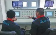  ?? WANG ZHUANGFEI / CHINA DAILY ?? Employees at Beijing ShouXingYo­ngAn Heating manage boilers via a central control panel.