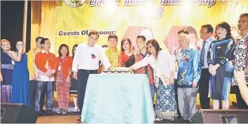  ??  ?? Chong (front, left) joins other guests on stage for a cake cutting ceremony to launch the DTTG Pre-Gawai dinner. Also seen are Ali (on Chong’s left) and Elias (front, second right).