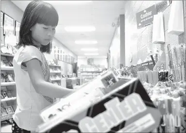  ?? RACHEL DICKERSON MCDONALD COUNTY PRESS ?? Susie Eh looks at items at the book fair at Noel Elementary. The school also recently had a science fair and an art fair.