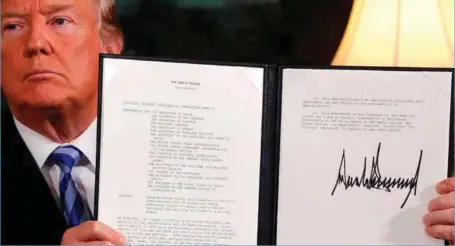  ?? FOTO: NTB SCANPIX ?? Donald Trump viser fram erklaering­en hvor han kunngjør at USA vil trekke seg fra atomavtale­n med Iran.