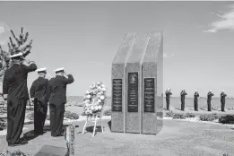  ?? JACOB MILHAM/DPMG/MC2 ?? Sailors assigned to the Arleigh Burke-class guided missile-destroyer USS Cole render honors at the USS Cole Memorial at Naval Station Norfolk during a commemorat­ion of the Oct. 12, 2000, terrorist attack in Yemen that killed 17 sailors.