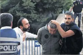 ?? Tolga Adanali Associated Press ?? A MAN IN MUGLA spits at a member of Turkey’s armed forces as he is taken away by police, along with others suspected of being involved in the coup attempt.