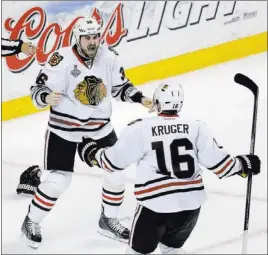  ?? CHARLES KRUPA/ THE ASSOCIATED PRESS ?? Blackhawks center Dave Bolland, left, celebrates his decisive goal with Marcus Kruger in Game 6 of the Stanley Cup Finals against the Bruins on Monday night at Boston. Bolland scored with 59 seconds remaining for the Blackhawks’ second goal in a...