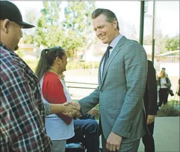  ?? Dania Maxwell Los Angeles Times ?? RESIDENTS FROM Century Villages at Cabrillo greet Gov. Gavin Newsom, who met with local government­s — including Huntington Beach, which the state sued — to press them to comply with the housing supply law.