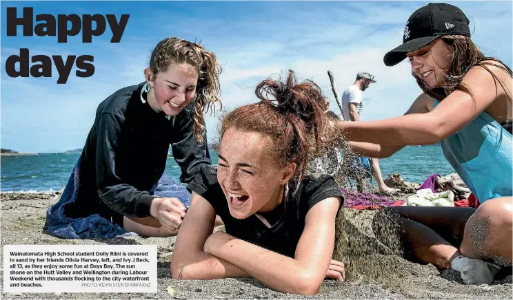  ?? PHOTO: KEVIN STENT/FAIRFAXNZ ?? Wainuiomat­a High School student Dolly Riini is covered in sand by her friends Olivia Harvey, left, and Ivy J Beck, all 13, as they enjoy some fun at Days Bay. The sun shone on the Hutt Valley and Wellington during Labour Weekend with thousands flocking...