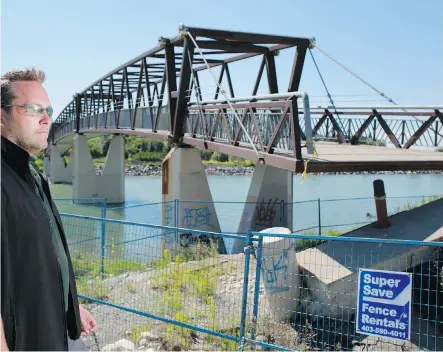  ?? Photos: Gavin Young/Calgary Herald ?? Parks planner Joey Young takes in Bridge 14 at the Bow River, one of several waiting to be repaired after last June’s flooding.