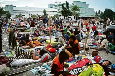  ?? Muhammad Rifki/AFP ?? Equipes médicas atendem vítimas de terremoto e tsunami em Palu, na ilha de Sulawesi, na Indonésia