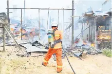  ?? ?? PADAM: Seorang anggota bomba berusaha memadamkan kebakaran.