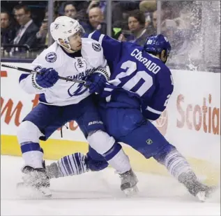  ?? MARK BLINCH, THE CANADIAN PRESS ?? Maple Leafs’ Frank Corrado and Tampa Bay Lightning’s Tyler Johnson battle along the boards on Tuesday night at the Air Canada Centre in Toronto. The Leafs used a big third period to upset the Lightning, 4-1.