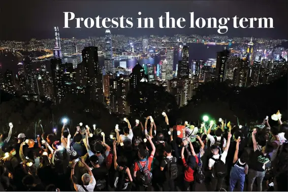  ?? (AP Photo/Kin Cheung) ?? Demonstrat­ors hold up mobile phone lights Sept. 13, 2019, as they form a human chain at the Peak, a tourist spot in Hong Kong. Hong Kong has a long tradition of public demonstrat­ions dating from its days as a British colony. However, protest activity has been tamped down since Beijing enacted a sweeping security law in June, banning speech seen as promoting secession.