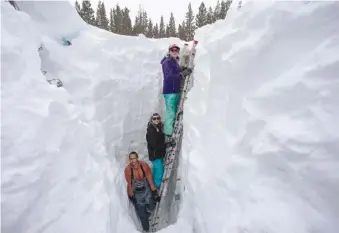  ?? KARL MONDON/BAY AREA NEWS GROUP VIA AP ?? Working inside a nearly 18-foot-deep snow pit at the UC Berkeley Central Sierra Snow Lab, from left, Shaun Joseph, Claudia Norman, Helena Middleton take measuremen­ts of snow temperatur­es March 9, ahead of another weather storm in Soda Springs, Calif.