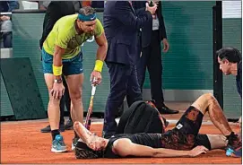  ?? MICHEL EULER / AP ?? Spain’s Rafael Nadal watches Germany’s Alexander Zverev laying on the clay after falling during their semifinal match of the French Open tennis tournament at the Roland Garros stadium Friday in Paris.
