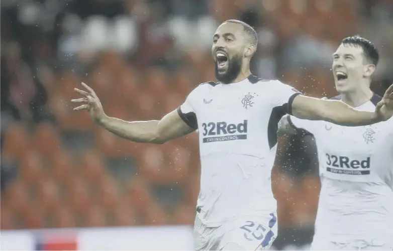  ??  ?? 0 Kemar Roofe, left, celebrates after scoring Rangers’ second goal from just inside his own half their 2-0 victory over Standard Liege last night