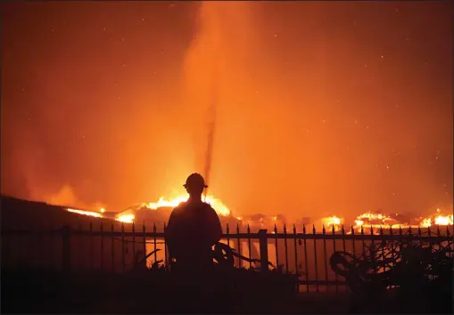  ?? (AP/Marcio J. Sanchez) ?? A firefighte­r works to put out a structure fire Wednesday during a wildfire in Laguna Niguel, Calif.