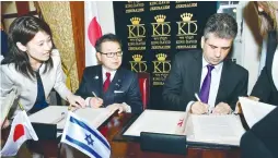  ?? (Rafi Kotz) ?? ECONOMY MINISTER ELI COHEN and his Japanese counterpar­t, Hiroshige Seko, sign an agreement for collaborat­ion between the two countries on business and cyber security ventures in Jerusalem yesterday.