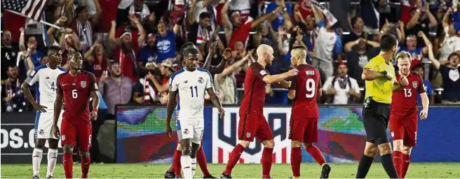  ??  ?? Well done: Forward Bobby Wood (third from right) of the United States is congratula­ted by teammate Michael Bradley after scoring against Panama in the World Cup qualifier at the Orlando City Stadium on Friday. Bottom: Christian Pulisic celebratin­g...
