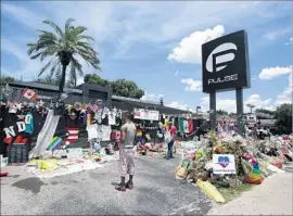  ?? John Raoux Associated Press ?? MOURNERS’ tributes decorate the Pulse nightclub in Orlando a month after the 2016 massacre. Plans call for the club to be transforme­d into a formal memorial.