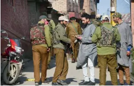  ?? — PTI ?? Security personnel check identity card of a youth during a search operation at Kawdara in downtown of Srinagar on Wednesday.