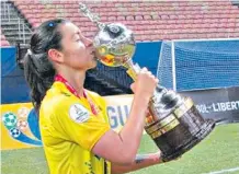  ?? ARCHIVO / ETCE ?? La jugadora Yoreli Rincón levanta el trofeo del título continenta­l.