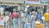  ?? ANI ?? People stand outside an electronic­s shop in Surat on Tuesday. n