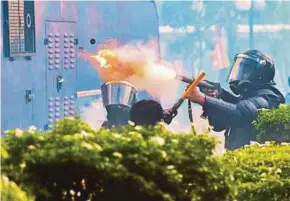  ?? AFP PIC ?? A policeman firing tear gas to disperse university students protesting to demand the resignatio­n of Sri Lanka’s President Gotabaya Rajapaksa, in Colombo on Thursday.