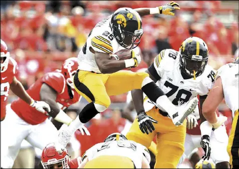  ?? GETTY IMAGES ?? Akrum Wadley (leaping over a teammate in a Sept. 24 game against Rutgers) combined with fellow Iowa running back LeShun Daniels for 2,340 rushing/receiving yards and 23 touchdowns this season.