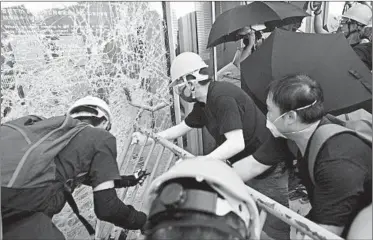  ?? ANTHONY WALLACE/GETTY-AFP ?? Protesters attempt to smash their way into the Hong Kong’s Legislativ­e Council complex on Monday.