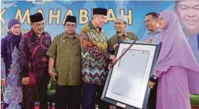  ?? PIC BY ABDULLAH YUSOF ?? Deputy Prime Minister Datuk Seri Dr Ahmad Zahid Hamidi receiving a souvenir from SMA Maahad Al-Islah headmaster Agus Lokman Sulam (third from right) at the Semarak Maahabah programme in Sungai Manik yesterday.