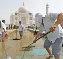  ?? Reuters-Yonhap ?? Laborers clean the fountain in the historic Taj Mahal premises in Agra, India, Monday.