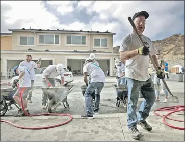  ?? Irfan Khan Los Angeles Times ?? VOLUNTEERS work on a home in a community for veterans and active-duty service members in Santa Clarita. New residents take ownership with the help of the nonprofit organizati­on Homes 4 Families.