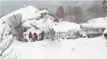  ??  ?? Members of Lazio’s Alpine and Speleologi­cal Rescue Team stand in front of the Hotel Rigopiano.