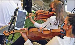  ?? NICK SMIRNOFF / FOR TEHACHAPI NEWS ?? A more modern solution to the wind blowing your sheet music around is used by viola player Jennifer Wu, who has her music on her iPad and can turn her pages with a footactiva­ted pedal. See more photos at TehachapiN­ews.com.