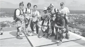  ??  ?? Hii (third left) posing with base jumpers at the top of Wisma Sanyan in this file photo.