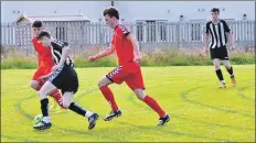  ?? 01_B27footy03 ?? Lamlash player Johnny Sloss dribbles the ball through the Shiskine defence.