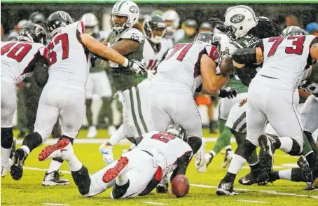  ?? THE ASSOCIATED PRESS ?? Atlanta Falcons quarterbac­k Matt Ryan, on ground, fumbles during Sunday’s game against the New York Jets in East Rutherford, N.J., Sunday. After briefly expressing his frustratio­n, Ryan looked for solutions — and his leadership helped the Falcons end...