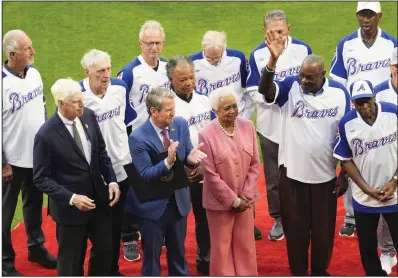  ?? (AP/John Bazemore) ?? Billye Aaron, wife of the late Hank Aaron, stands Monday with Georgia Gov. Brian Kemp (second from left), Atlanta Braves chairman and CEO Terry McGuirk (left), Dusty Baker (right) and players from the 1974 Atlanta Braves team during a ceremony to mark the 50th anniversar­y of Aaron breaking Babe Ruth’s home run record team before a game against the New York Mets in Atlanta.