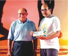  ??  ?? Ashok L. Odhrani hands over the Rs1 million cheque to Vipul at the 4th Internatio­nal Yoga Day event in Dubai on June 21.