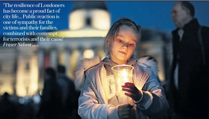  ??  ?? A young girl lights a candle during a sombre vigil in Trafalgar Square yesterday. Hundreds of Londoners and tourists gathered quietly as night fell to honour those who died in Wednesday’s terrorist attack on Westminste­r