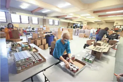  ?? JOE RONDONE/THE COMMERCIAL APPEAL ?? Pam Mccoid prepares food boxes inside St. Anne Church that are given away Monday through Thursday every week for low-income families in need. Since March they have served nearly 30,000 families with non-perishable food supplies.