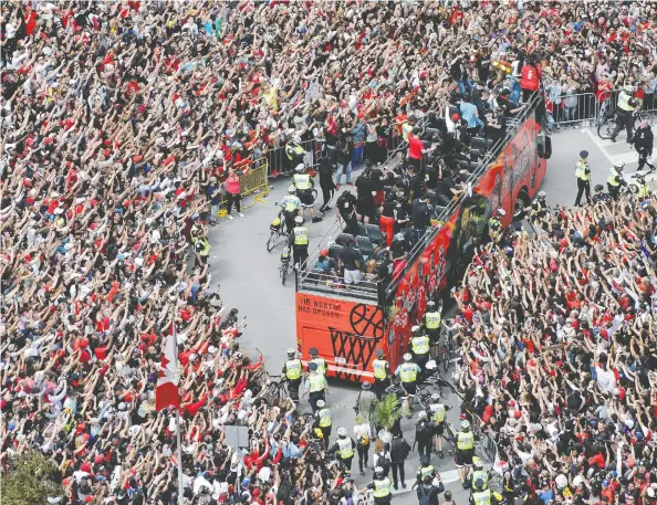  ?? ANDREW LAHODYNSKY­J / THE CANADIAN PRESS ?? Fans cheer as the Toronto Raptors Championsh­ip parade passes by on Monday. It was a remarkable way to end a remarkable season.