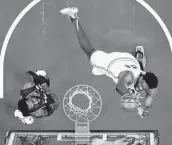  ?? Matt Slocum / Associated Press ?? Philadelph­ia's Joel Embiid, right, goes up to score two of his 39 points in Wednesday’s victory over the Nets.