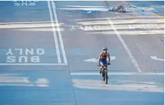  ?? Hyoung Chang, The Denver Post ?? A bicyclist pedals down the 16th Street Mall on March 24 after Mayor Michael Hancock issued a stay-at-home order for Denver.