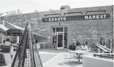  ?? PATRICK BREEN/THE REPUBLIC ?? Diners enjoy fresh food and drinks last weekend at the DeSoto building, a 1920s-era structure at Central Avenue and Roosevelt Street that reopened this month as a public market and eatery. The project received $250,000 in grant funding.